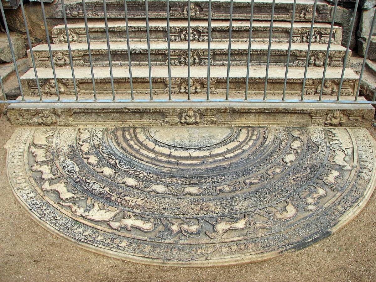 An ancient carved moonstone at the foot of stone steps in Anuradhapura